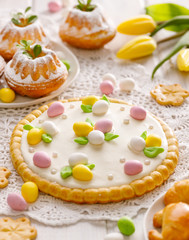 Mazurek pastry, traditional Polish Easter cake made of shortcrust pastry with  white chocolate cream, decorated with marzipan eggs  and sugar pearls on the holiday table,  close-up.  Sweet dessert