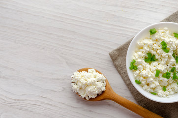 A glass bottle with kefir and kefir grains with bread rolls on the wooden table
