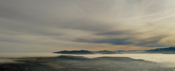 Fog in mountains before sunrise, mountain valley with clouds. View to mountains of the Carpathians