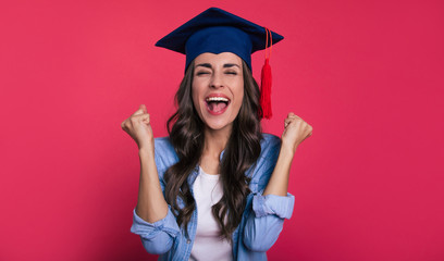 Lucky one. Close-up photo of a happy dark-haired girl in a casual outfit and a student cap, who is...