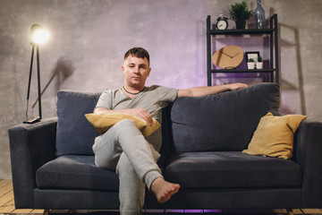 A man sitting on the couch watching TV at home