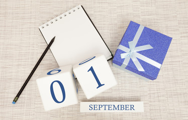 Gift box and wooden calendar with trendy blue numbers, September 1, business planner