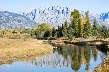 Snow Capped mountains reflected in the Snake River