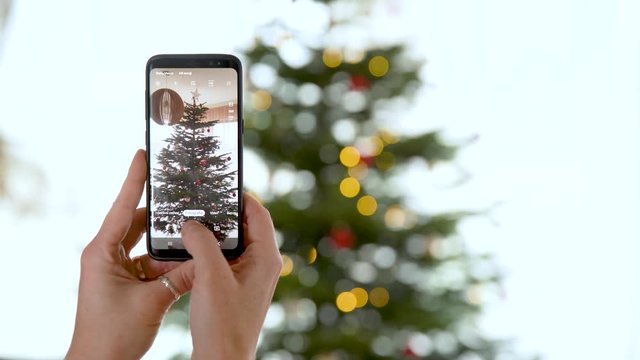 photo shoot with smart phone christmas tree decorated and shining in different colors