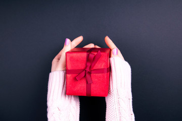 Woman's hands holding craft paper gift box
