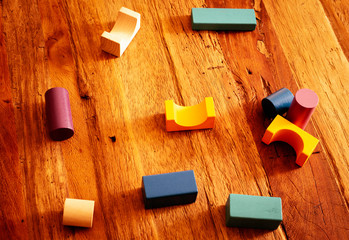Toys blocks, multicolor wooden building bricks, heap of colorful game pieces on a wood table.