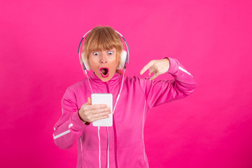 adult woman with mobile phone and headphones listening music with surprise