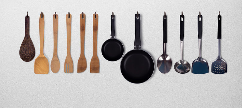 Set of kitchen utensils hanging on white wall background.stainless steel kitchenware,spatula,ladle,pan,pot