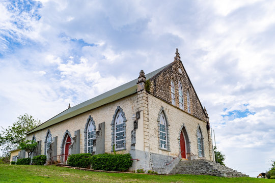 Vintage brick/ concrete wall chapel with red front door and stained glass windows in the countryside. Duncans Methodist Church in Trelawny parish, Jamaica, built in AD 1882.