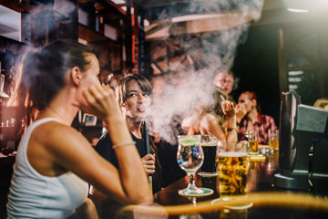 group of people smoking hookah in bar - obrazy, fototapety, plakaty