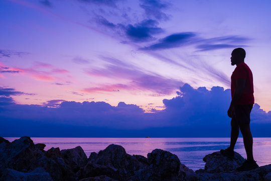 Young Man Standing On Cliff Edge Staring At Endless Ocean Water, Contemplating Life And Its Troubles As He Journeys Into The Unknown. Priorities, Decisions And Freedom Of Choice. Stepping Out In Faith