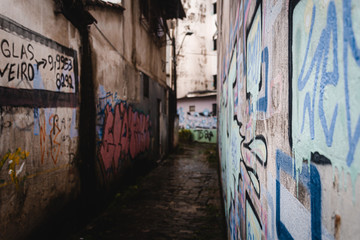 Callejon mojado en dia de lluvia con grafitis en las paredes