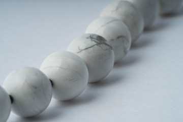 Handmade bracelet made of cacholong, black spinel and agate on a white background