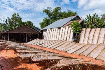 A man dry rice paper in yard
