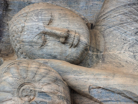 Detailed close-up of the ancient Reclining Buddha statue carved from solid granite rock at Gal Vihara, Polonnaruwa, Sri Lanka.
