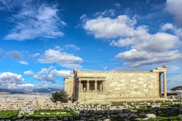The Erechtheion or Erechtheum at the Acropolis in Athens dedicated to both Athena and Poseidon and the Porch of the Caryatids under a beautiful sky with the city in the background.