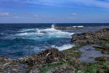 Blue atlantic ocean, white foam and volcanic rock