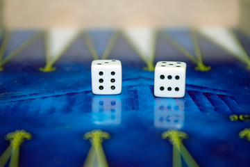 Dice on backgammon board  with chips and  acropolis on backround.  Selective focus. 