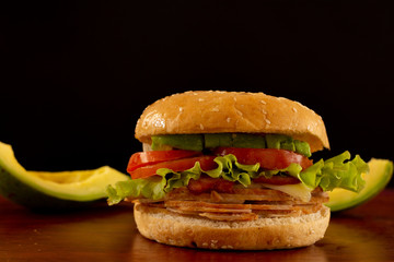 Front view smoked turkey hamburger whit avocado background.