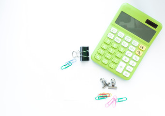 Green calculator and office accessories on white background,with copy space and top view.