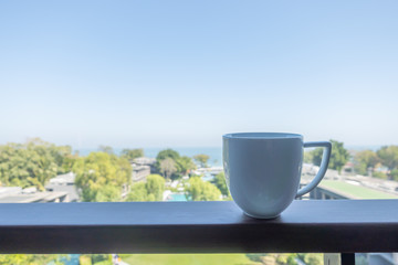 coffee cup on balcony with sea beach background