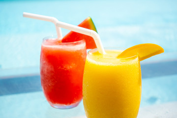 mango smoothie and watermelon smoothie with swimming pool and sea beach background