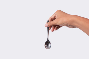 Hand holding Stainless steel teaspoon isolated on white background
