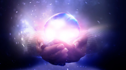 Magic particles emanating from female hands. Glass ball in the hands. Magic particles on the palms, magic, witchcraft.
