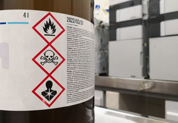 Chemical substance in a laboratory. Amber glass bottle. Tagged with GHS symblogy with toxicity,...