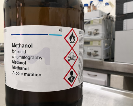 Amber glass bottle for lightning protection containing methanol, an HPLC grade alcohol, and a label with GHS warnings about toxicity, flammability and death. Chemical reagent in a scientific research 