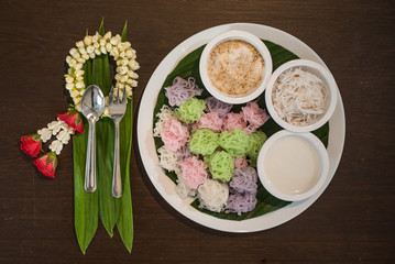 Colorful Thai Desserts (Ka-Nhom-Ray-Rai or Rang-rai ) Rice flour dumpling topped coconut milk and sugar mixed with sesame (Thailand traditional food)