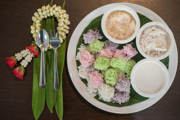 Colorful Thai Desserts (Ka-Nhom-Ray-Rai or Rang-rai ) Rice flour dumpling topped coconut milk and sugar mixed with sesame (Thailand traditional food)