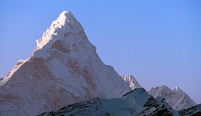 Driehoekige piramide van de majestueuze Ama Dablam (6814 m) piek op de achtergrond van blauwe lucht in Nepal, Himalaya-gebergte  grootsheid van de natuur concept