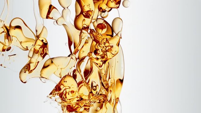 transparent orange gold oil bubbles and fluid shapes in purified water on a white gradient background. Side angle with crystal colored bubbles in purified cosmetic water backdrop with copy space