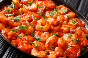 Fresh fried shrimp stewed in tomato sauce close-up in a plate. horizontal