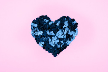 Heart of small blue hearts on a pink background. Valentine's day concept. Flat lay, top view.