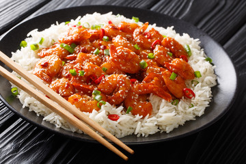 Fried sticky shrimps with garlic, chilli, sesame seeds and green onions served with rice close-up in a plate. horizontal