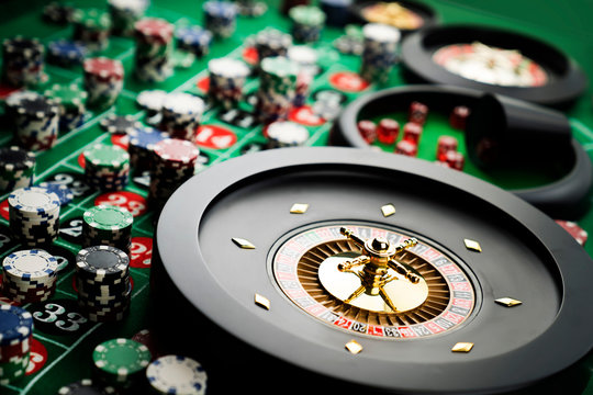 Casino theme, close up of roulette, red and black numbers, Stack of chips as background.