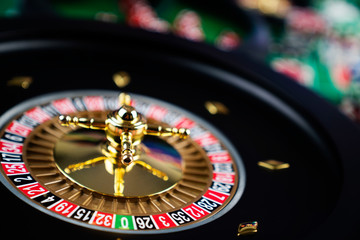 Casino theme, close up of roulette, red and black numbers, Stack of chips as background.