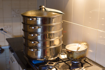 Juicy korean manti on a gas stove in a double boiler. Cooking delicious dishes, national Korean cuisine