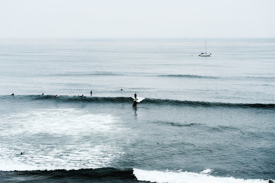 Dramatic seascape. Blue ocean and silhouette of surfers on a horizon