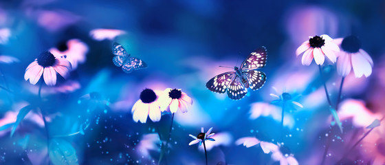 Obraz na płótnie Canvas Tropical butterflies and pink bright summer flowers on a background of blue foliage in a fairy garden. Macro artistic image. Banner format.