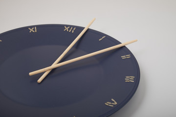 clock, time concept with rice on a blue plate, top view