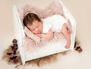 Newborn sleeping in tiny bed