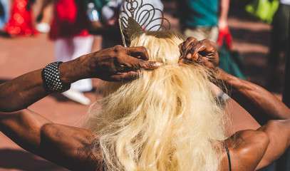 A participant of an AIDS Walk benefit dressed as a drag queen fixes his wig