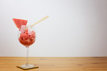 Fresh watermelon dessert in a beautiful glass on a stand and a wooden spoon