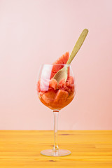 Juicy watermelon dessert in a large glass with a wooden spoon