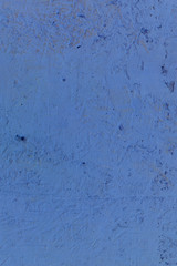 Blue textured background. Cement surface with cracks and scratches painted with light blue paint. Close-up, top view, vertical, plenty of free space for text.