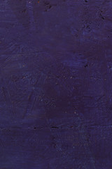 Violet textured background. Cement surface with cracks and scratches painted with purple paint. Close-up, top view, vertical, plenty of free space for text.