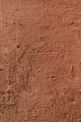 Brown background. A cement surface with cracks and scratches painted with brown paint. Close-up, top view, vertical, plenty of free space for text.